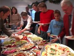 Gästerna flockas runt kocken och julbordet